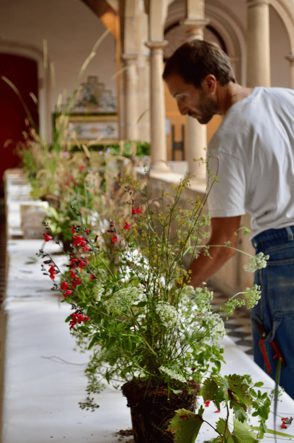 umělec u stolu s lučními květinami